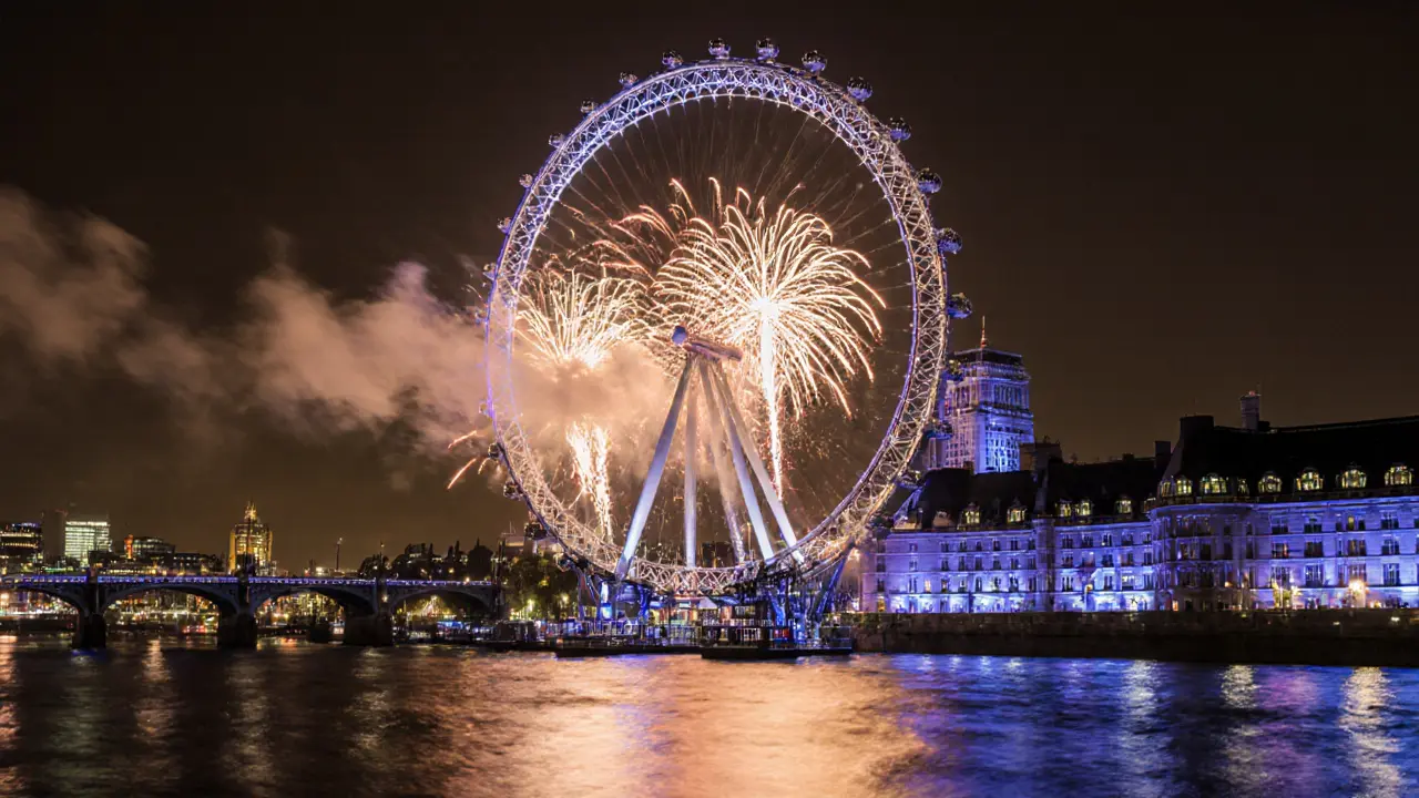 London Eye lit by fireworks over Thames during Bonfire Night, long exposure blur